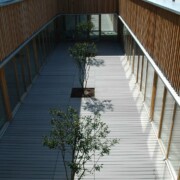 Innenhof mit WPC Terrassendielen und Holzfassade an einer Schule