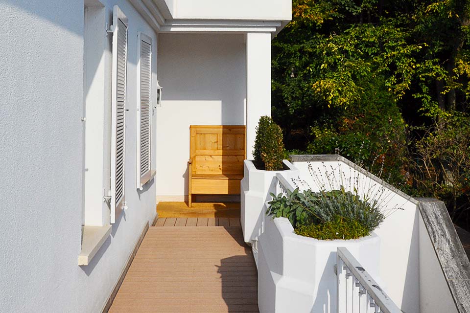 Außendiele aus WPC in braun auf umlaufenden Balkon vor modernem Haus