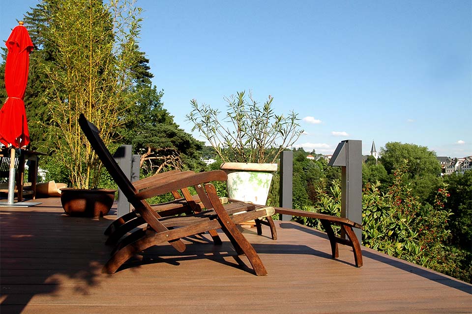 Balkon mit massiven, braunen WPC Balkondielen und Holzliegen