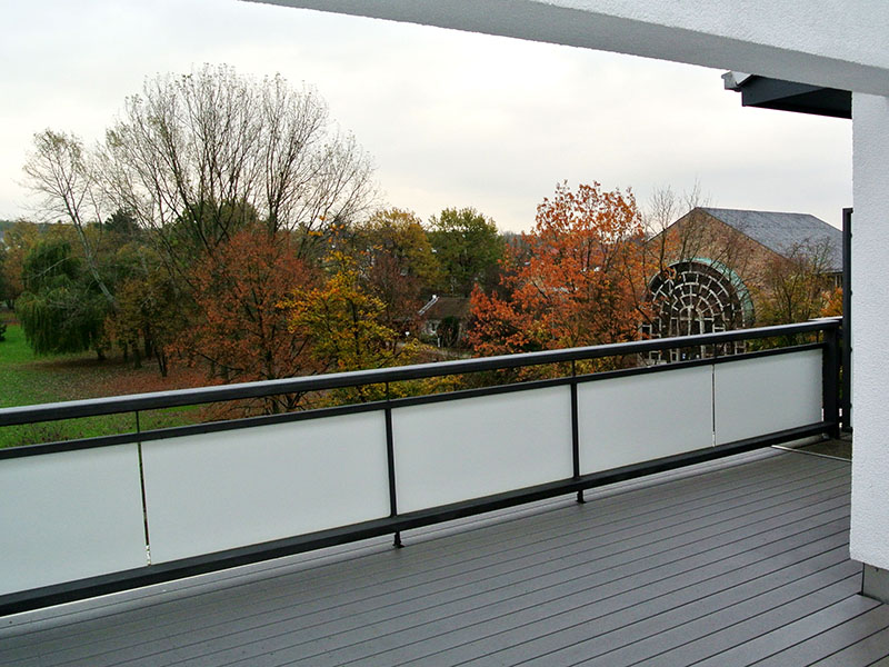 Pflegeleichter garuer Balkonboden aus WPC von MYDECK nach Regen. Balkon mit Park-Ausblick.