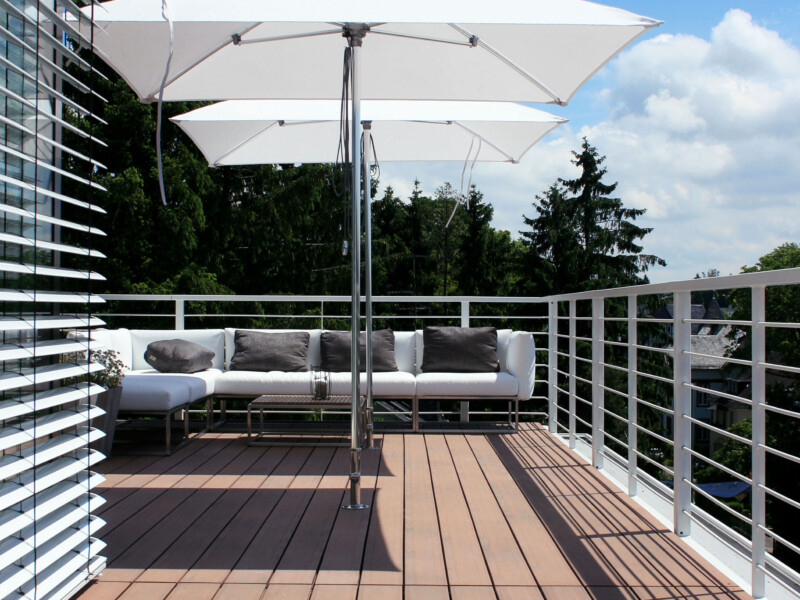 Moderner Balkon mit Sonnenschirmen und bildschönen dunkelbraunen Balkondielen - moderne Balkongestaltung