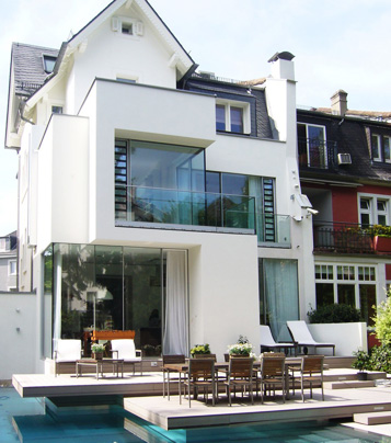 Wohnhaus mit höhenversetzen Terrassen auf denen Außendielen im modernen Design verlegt sind