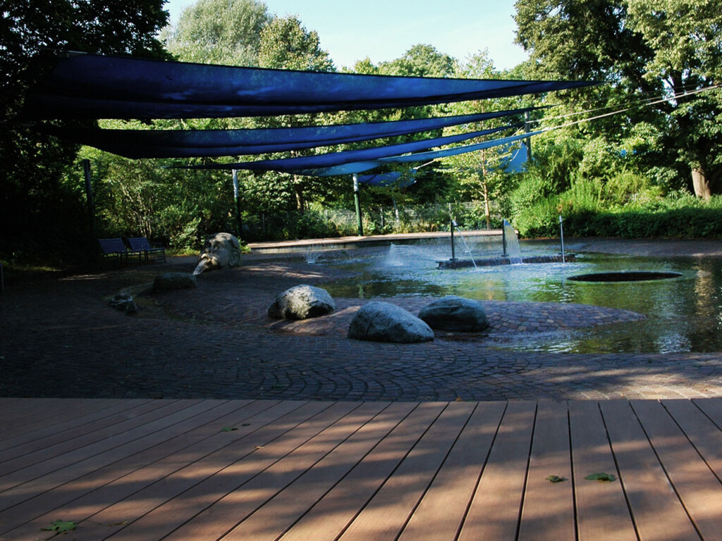 Stufenförmige Terrasse im Kinderplanschbereich des Schwimmbds Westbads München mit splitterfreien Premium WPC Dielen