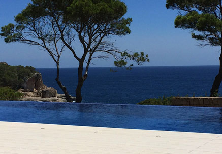 Poolumrandung mit WPC Terrassendielen und Blick auf Pool, Meer, Bäume