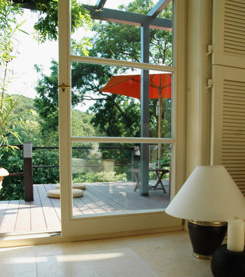 Blick aus moderne landhausschick Wohnung nach draußen auf Garten und moderne Terrassengestaltung