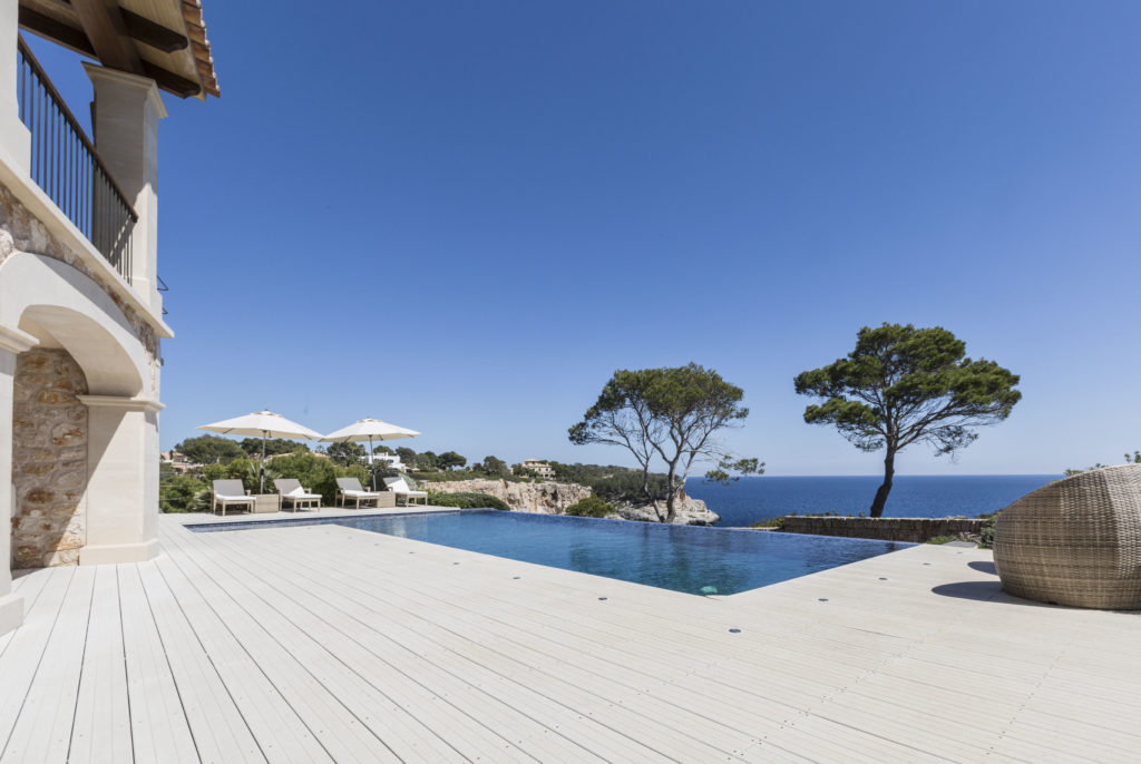 Die hellen WPC Dielen harmonieren mit den Möbeln auf der Terrasse und den Natursteinen der Villa und umranden bildschön den Pool.