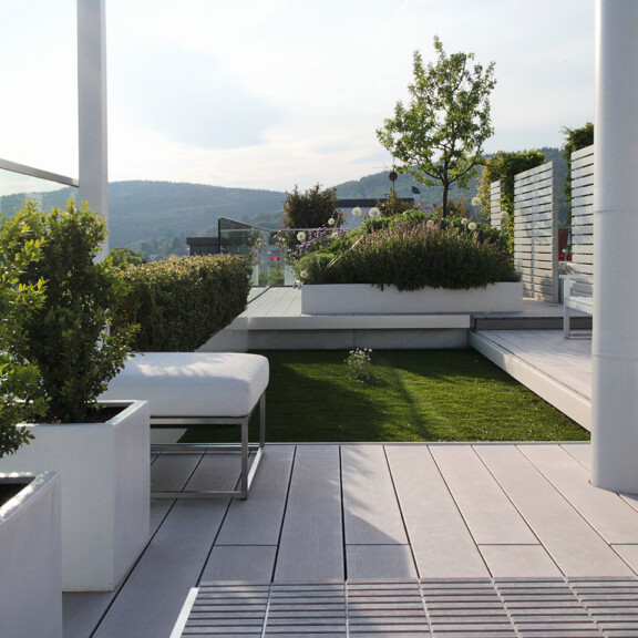 Moderne, großzügige Dachterrasse mit wetterfesten WPC Massivdielen in grau und Dachgarten