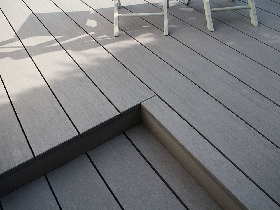 Die grauen Premium Dielen von MYDECK sind massiv und lassen sich wie Holz bearbeiten, so dass Stufen wie auf dieser Terrasse problemlos möglich sind.