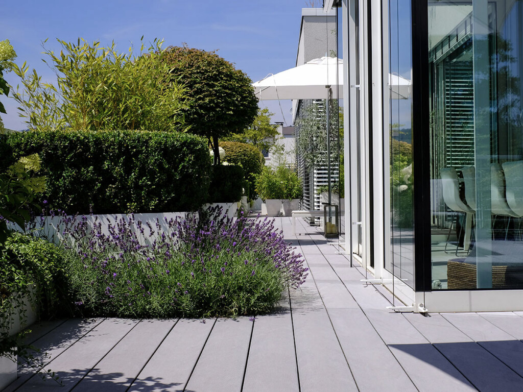 Terrassengestaltung mit grauen WPC Dielen und moderner mediterranerr Bepflanzung