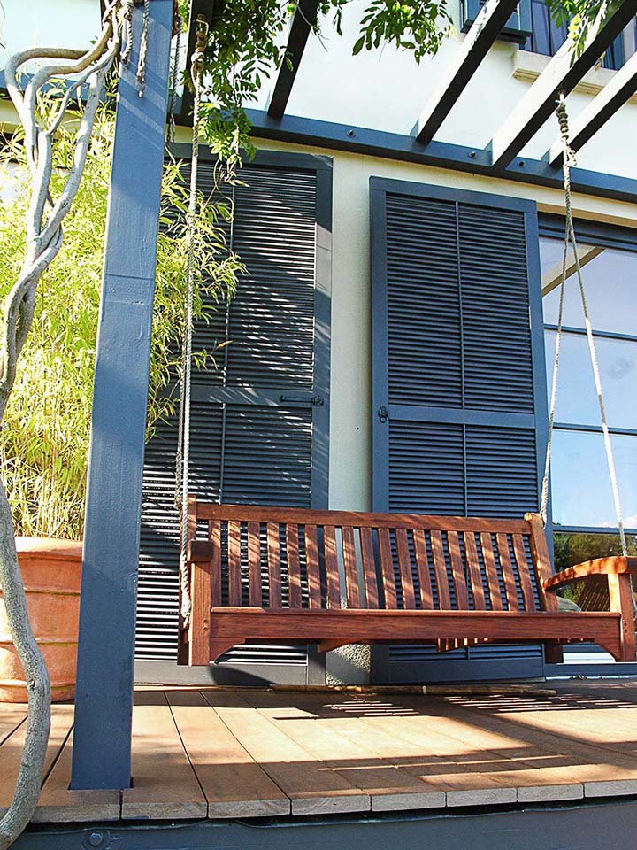 Gemütlicher Sitzplatz unter Pergola mit Pflanzenbewuchs auf WPC Terrasse