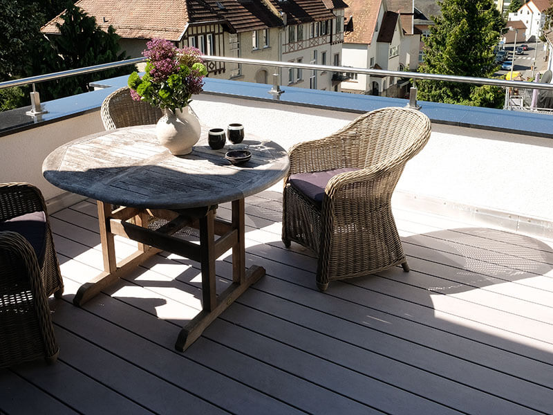 Terrassendielen WPC grau Dachterrasse Sitzgruppe Korbmöbel