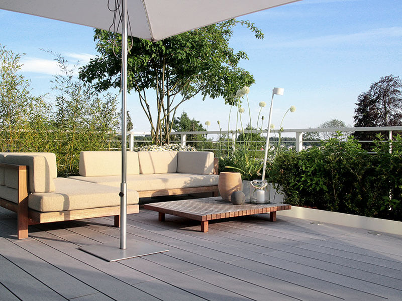 Balkon mit grauen WPC (aus Holz und Kunststoff) und gemütlicher Sitzecke mit Outdoor-Sofa