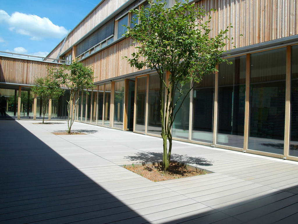 Die grauen WPC Dielen in dem Innenhof der Schule sind splitterfrei und ergänzen ideal die moderne Architektur.