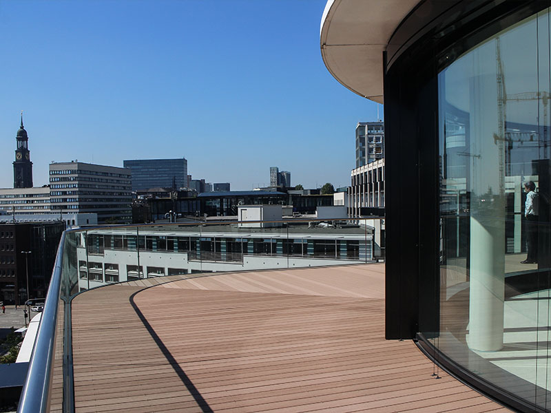 Spiel mit der Richtung der WPC Dielen um die Terrasse an die runde Form des Gebäudes anzupassen