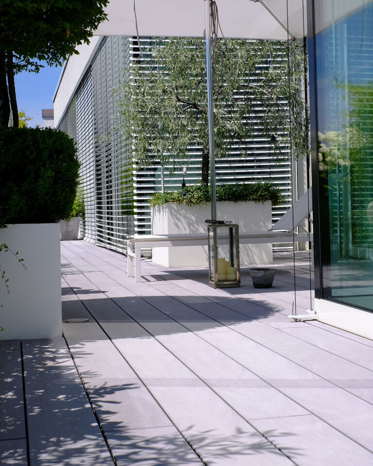 Moderne Terrasse mit grauen WPC Vollprofildielen - Terrasse mit integriertem Garten