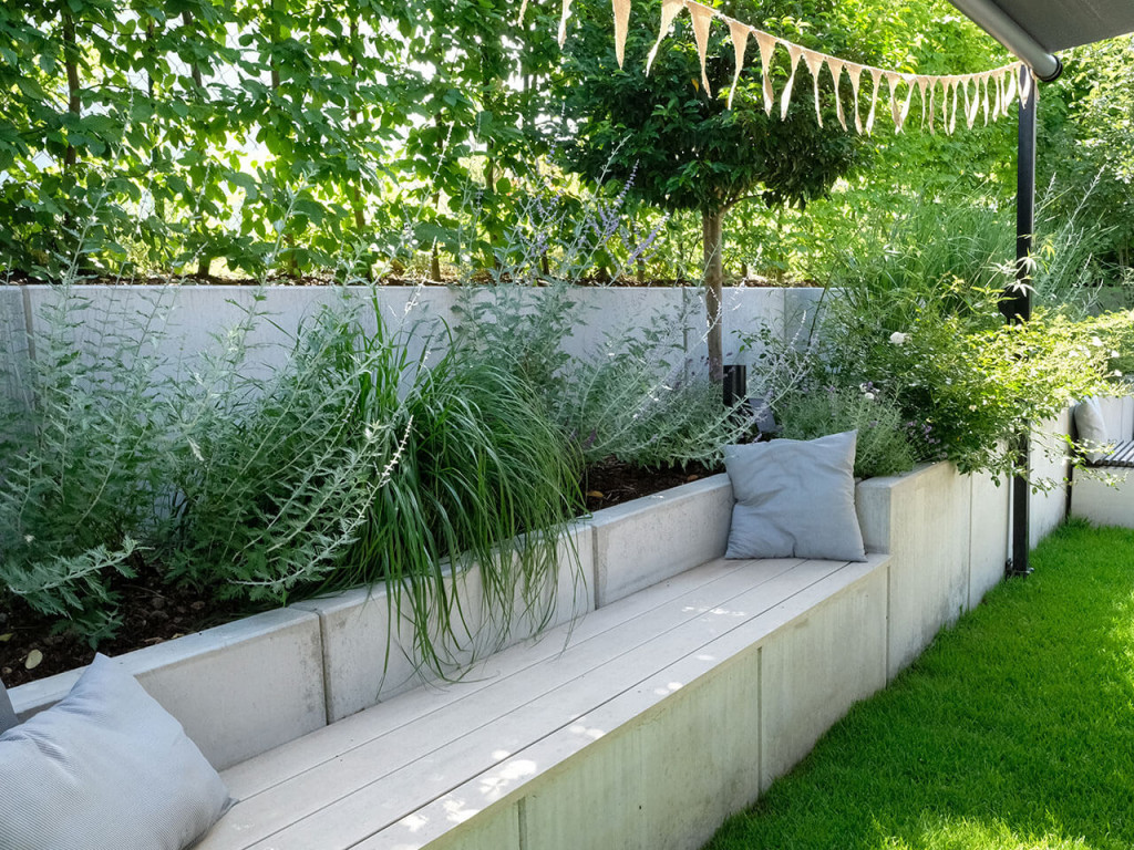 Bank mit WPC Dielen als Teil der Gartengestaltung, gemütlicher Sitzplatz auf Bank