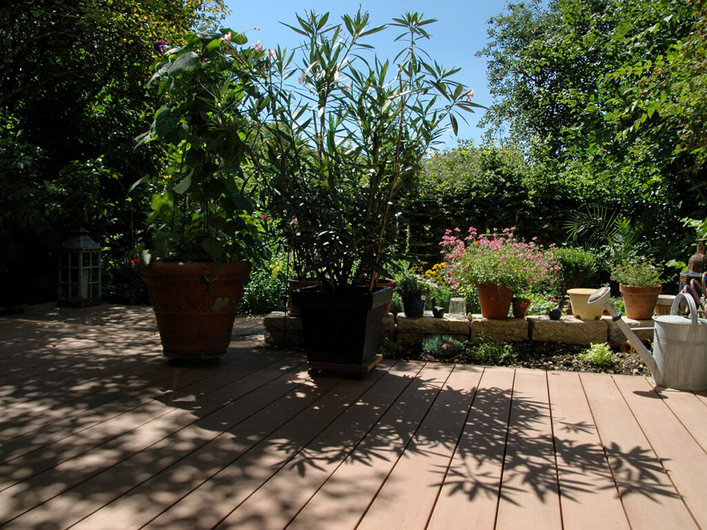 Terrassengestaltung mediterran mit WPC Dielen braun, Naturstein und mediterranen Pflanzen