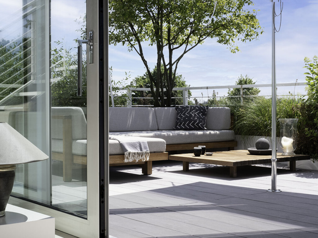 Sitzecke auf Terasse mit grauen WPC Terrassenbelag und Hochbeeten