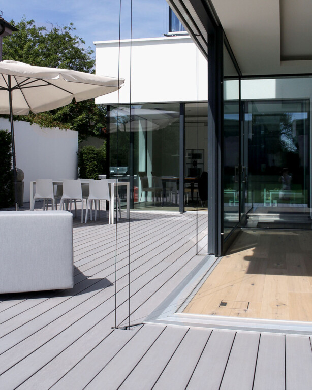 Verlegerichtung der WPC Terrasse in gleicher Richtung wie Wohnzimmer mit großen Glas-Schiebetüren