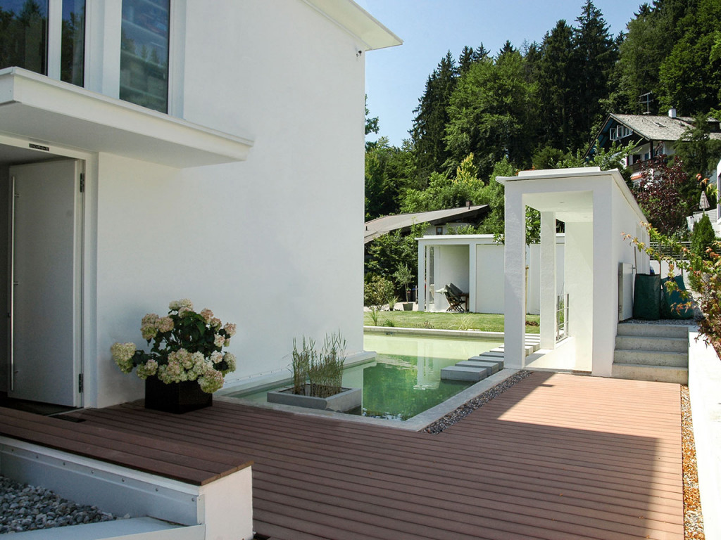 Modernes Holz mit modernem Holzboden aus Holz und Polyethylen, Wasserfläche vor Haus