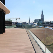 Geschwungene Terrasse mit hellbraunen WPC Terrassendielen massiv