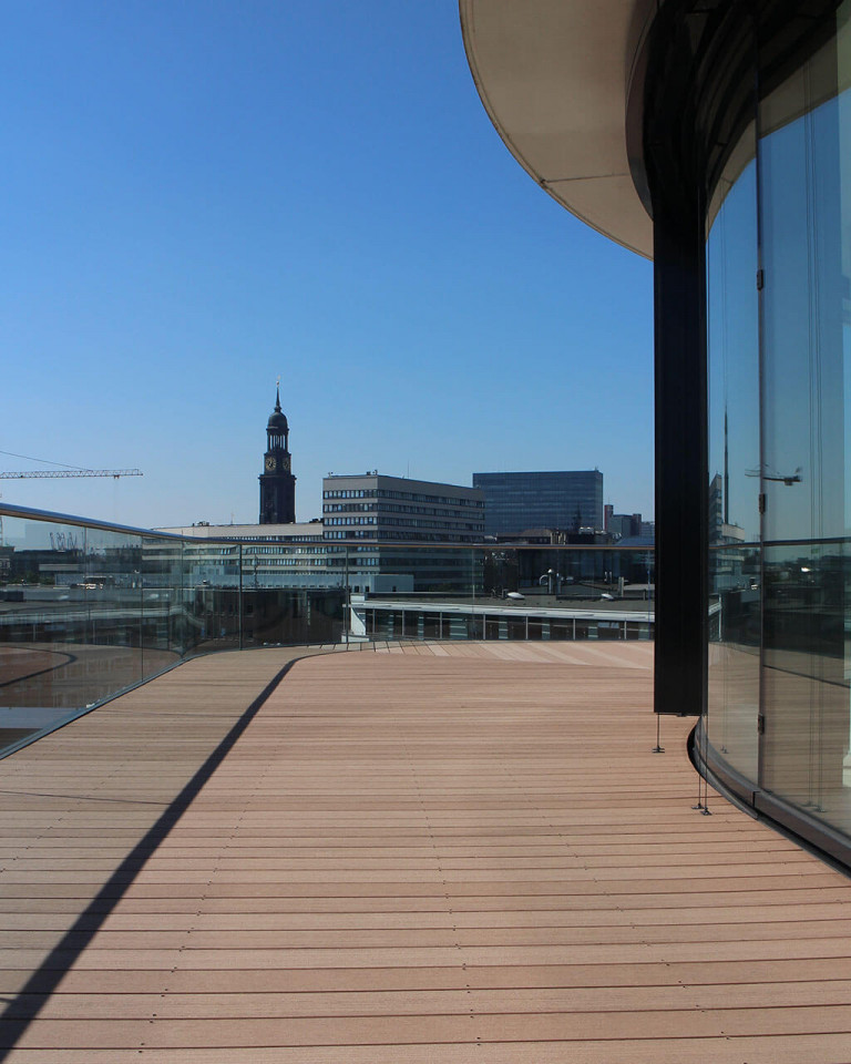 Geschwungene Terrasse mit hellbraunen WPC Terrassendielen massiv auf der Dachterrasse