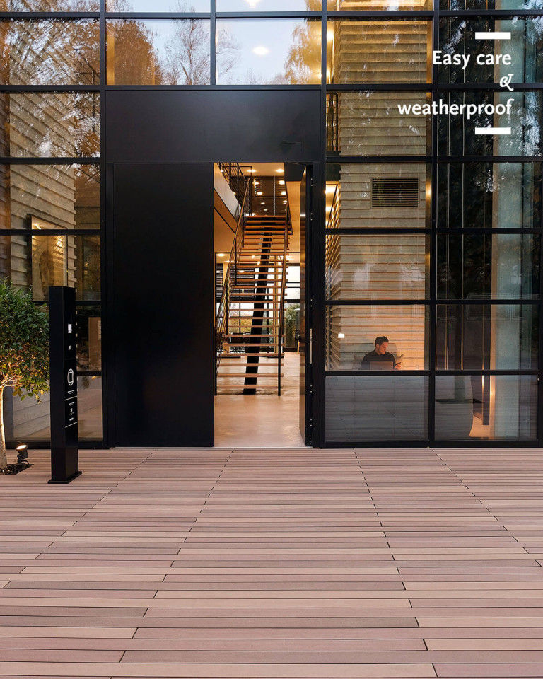 WPC boards in various shades of brown in the design of tropical wood in front of a modern building