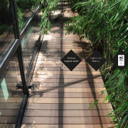 Wood-look WPC decking boards on patio walkway with side bamboo bed