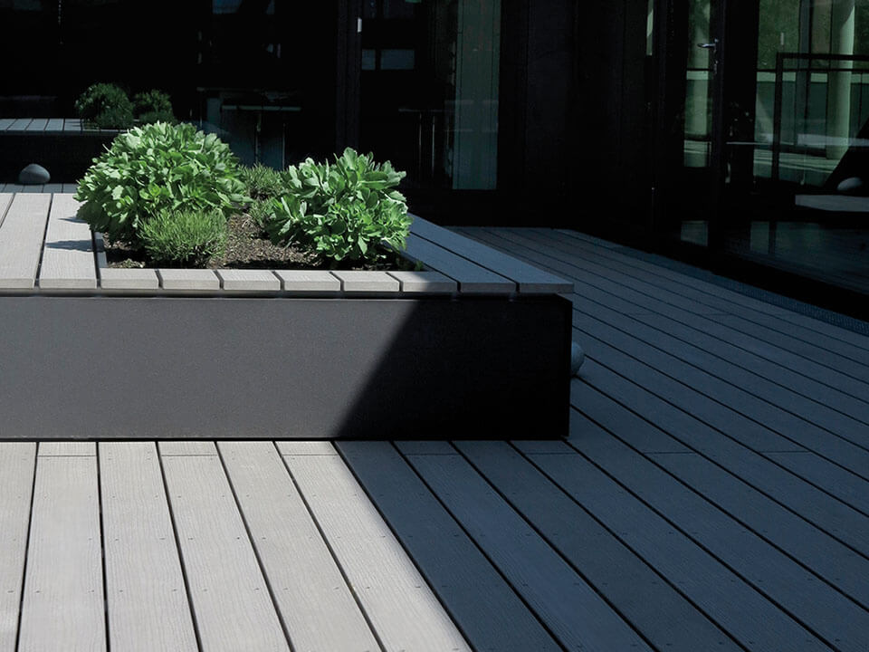 Kombination aus Hochbeet und Sitzinseln mit grauen WPC Terrassenbelag - querformat