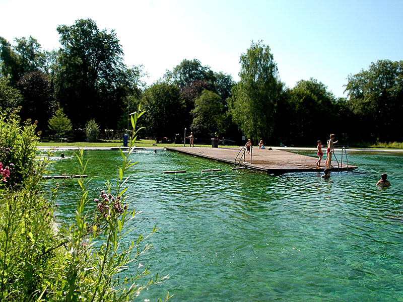 Badeinsel mit brauen WPC Dielen im Maria Einsiedel Bad in München, Querformat