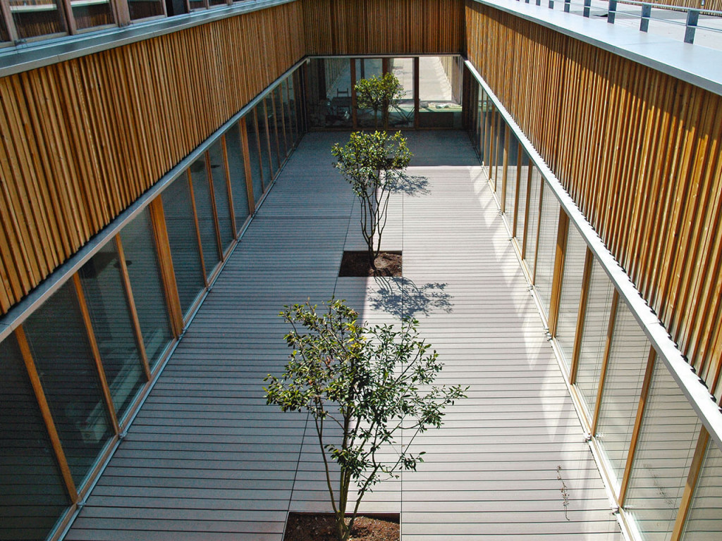 Blick in Innenhof Schule mit grauer WPC Terrasse