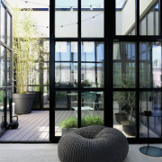 Patio modern mit schwarzen Sprossenfenstern und grauen WPC Dielen