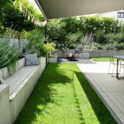 Terrasse mit hellen WPC Dielen in Garten und mt Bank, welche ebenso mit den Dielen verlegt sind